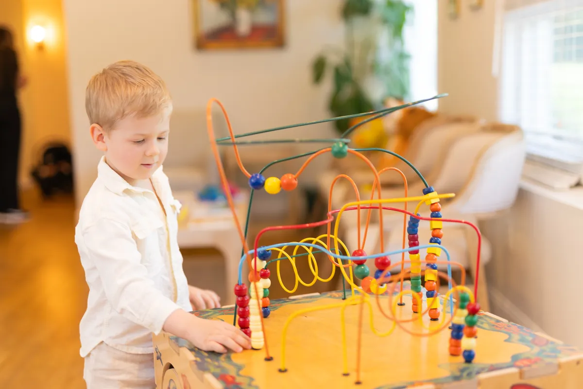 A child playing with the bead-maze toy in the waiting area